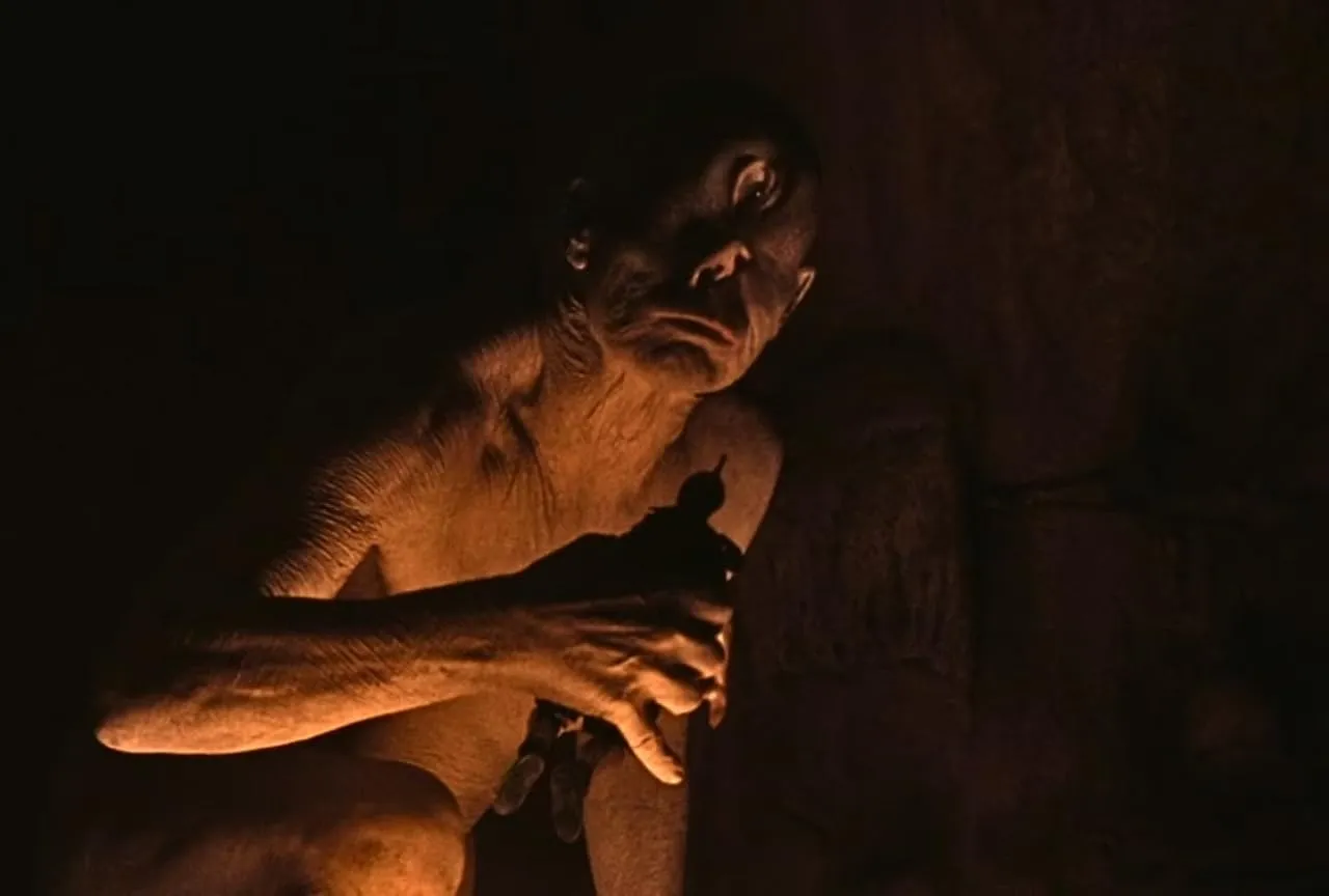 Polyphemus the Cyclops in Christopher Nolan’s The Odyssey, shown inside his dark cave illuminated by firelight.